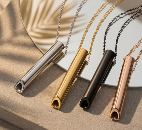 Five necklaces with cylindrical pendants in silver, gold, black, and rose gold on a neutral background.