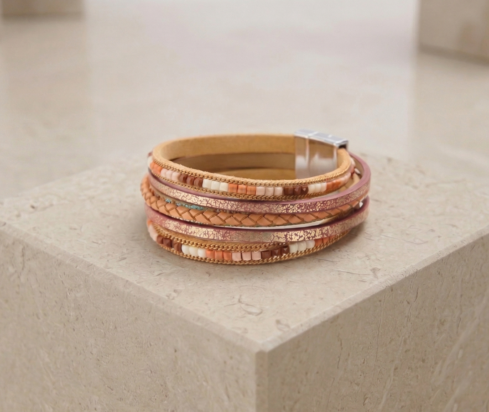 Stack of woven bracelets on a textured stone surface