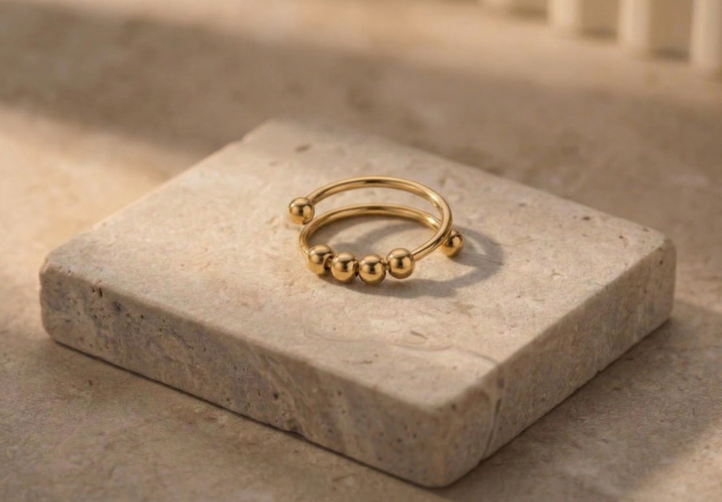 Gold ring with bead details on a stone surface