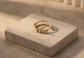 Gold ring with bead details on a stone surface